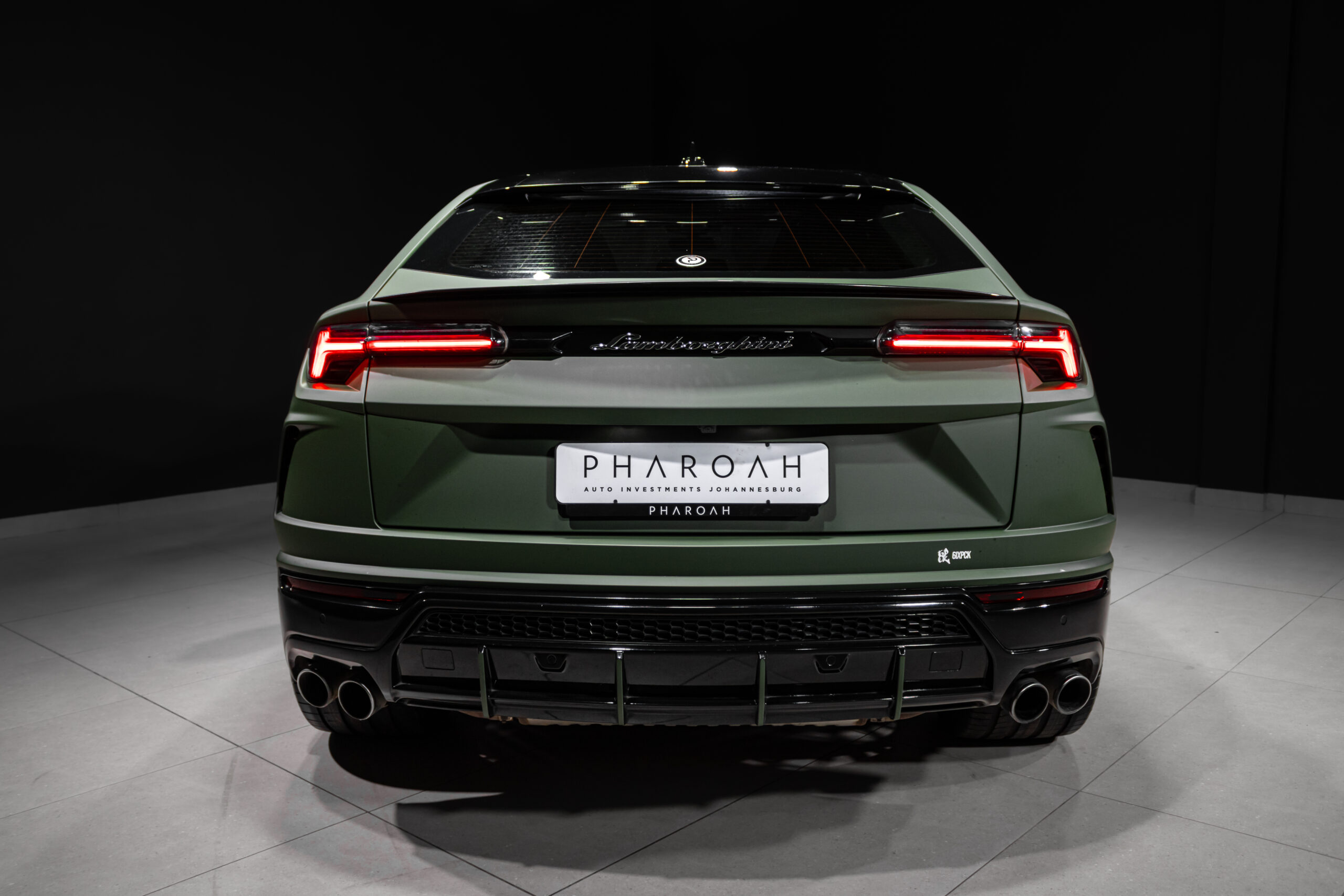 Rear of a matte green Lamborghini SUV with red taillights, quad exhausts, and a PHAROAH license plate.