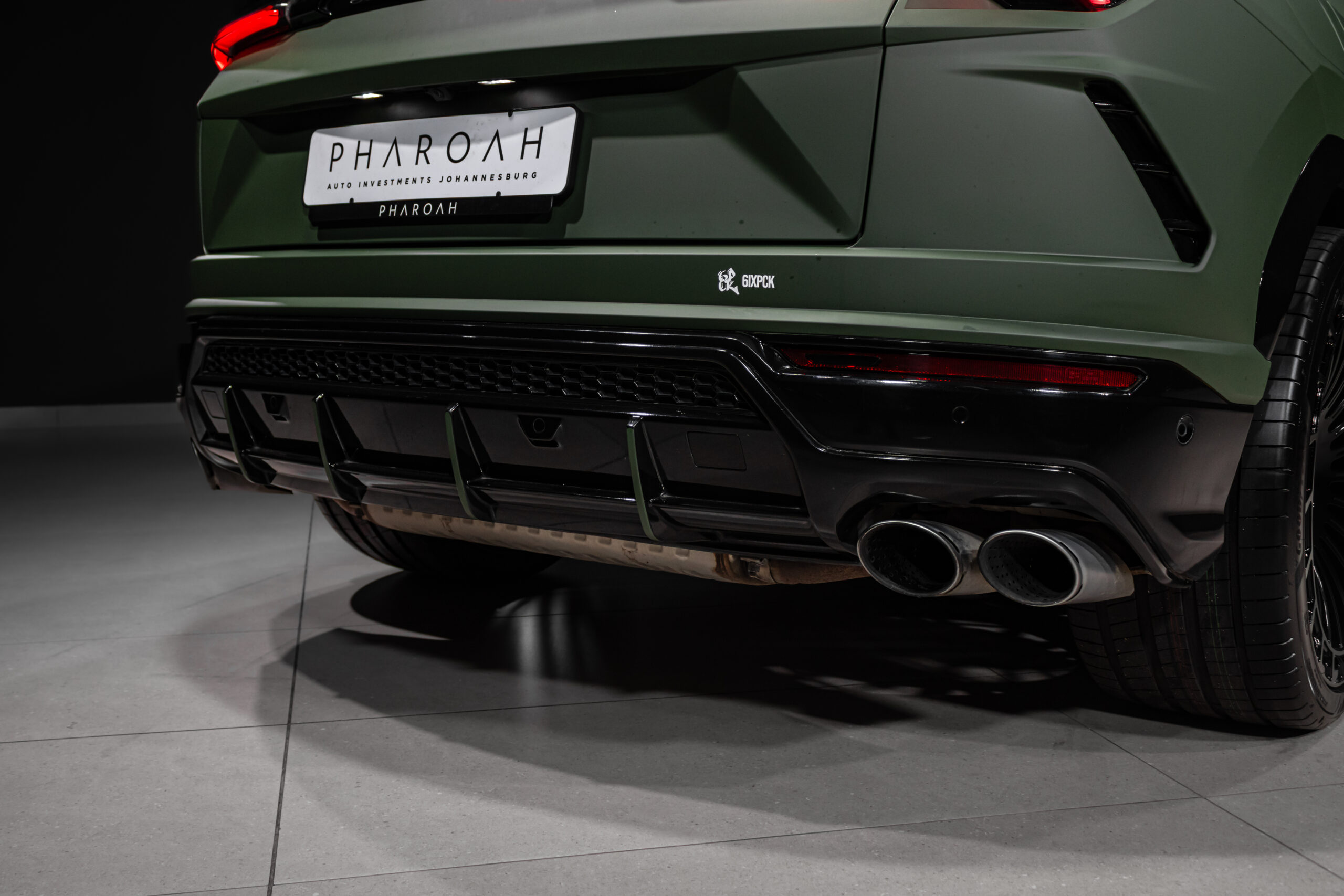 Rear view of a matte-green car, showing quad exhaust pipes, diffuser, and a license plate reading 'PHAROAH' at the center.