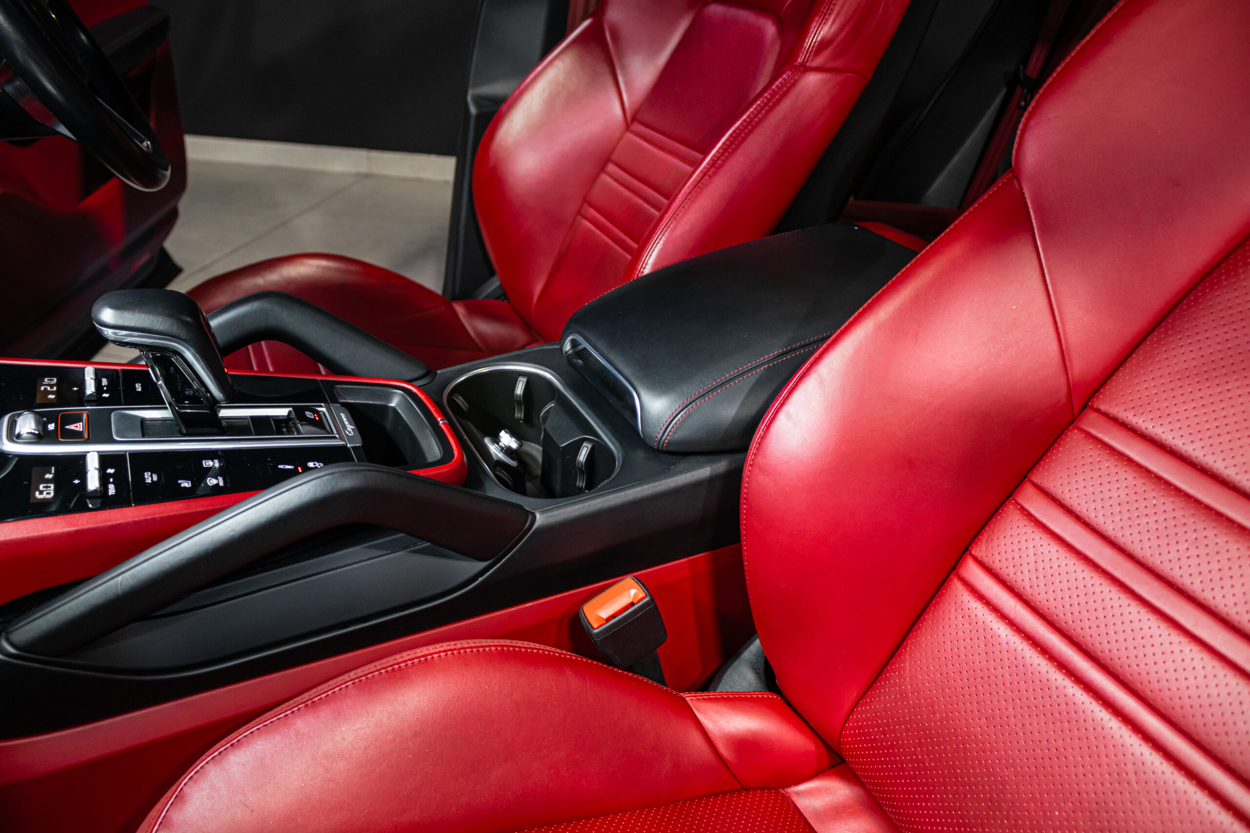 Red leather car interior with a black center console and gear shifter in view