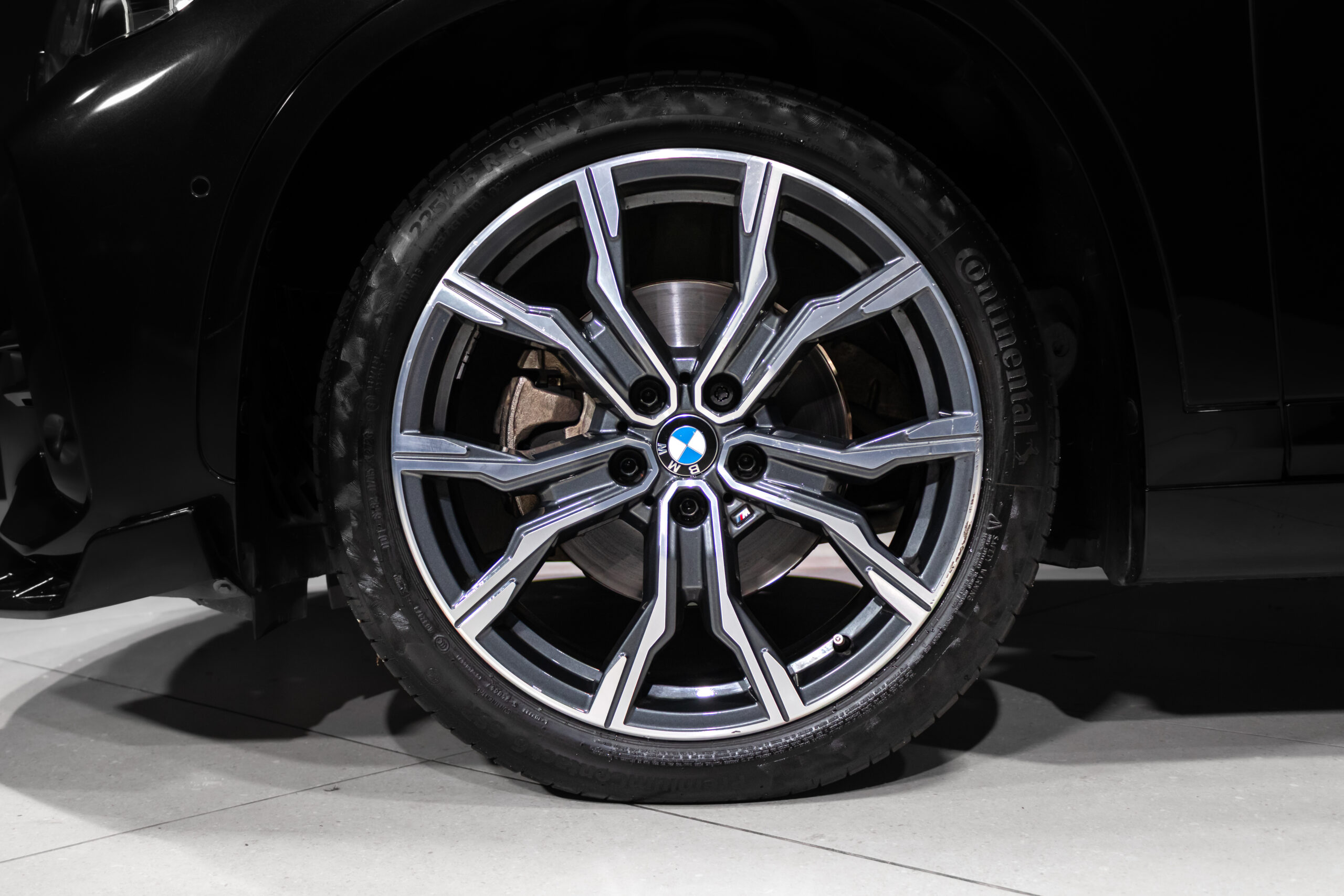 Close-up of a BMW alloy wheel with a visible brake rotor behind the multi-spoke rim.