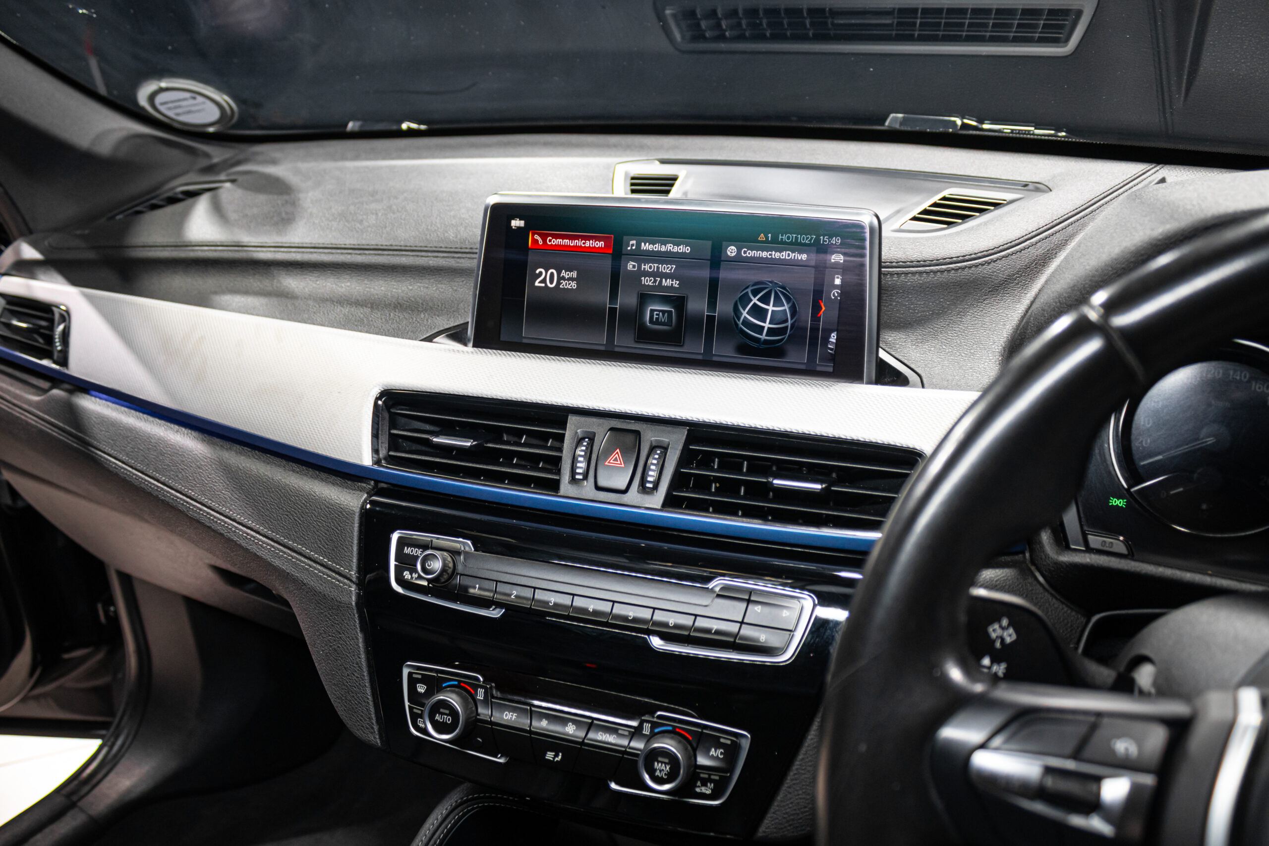 Center console of a car with a widescreen infotainment display and climate controls on the dashboard